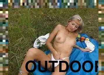 Horny blonde masturbates outdoors with a bottle