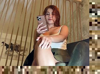 Sitting on a chair with no underwear to show off her natural hairy pussy, cute redhead teases