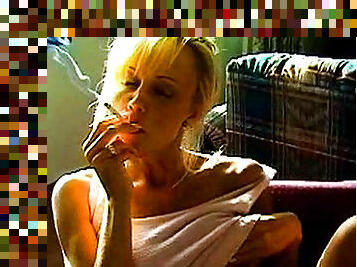 Hot blonde is smoking a cigarette in a hot way