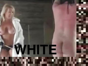 Mistress in white fur coat plays with slaves