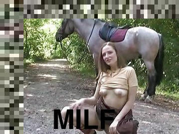 Stunning milf is posing in front that horse