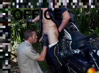 Two police officers drop their pants and suck each other