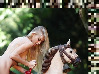 Artistic erotic outdoor solo with slender Nancy A. on a toy horse
