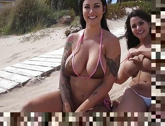 Two busty girls in bikinis tanning topless