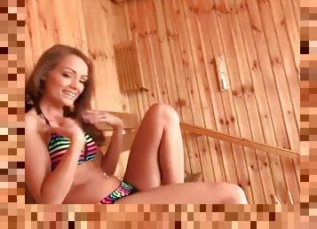 Bikini beauty in the sauna gives a footjob
