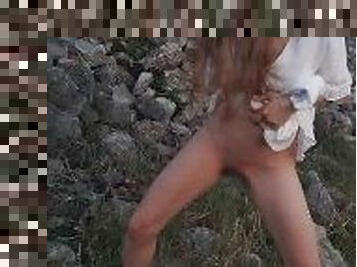 Lovely girl in a white dress pissing outdoors